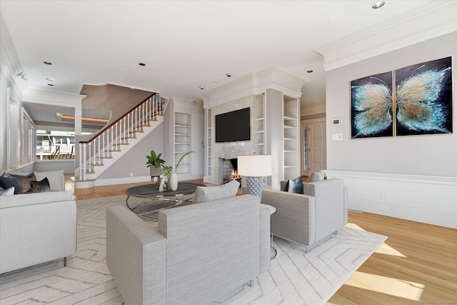 33 Palmer Rd, Waterford, CT 06385 - living area featuring crown molding, a large fireplace, stairs, wood finished floors, and built in features