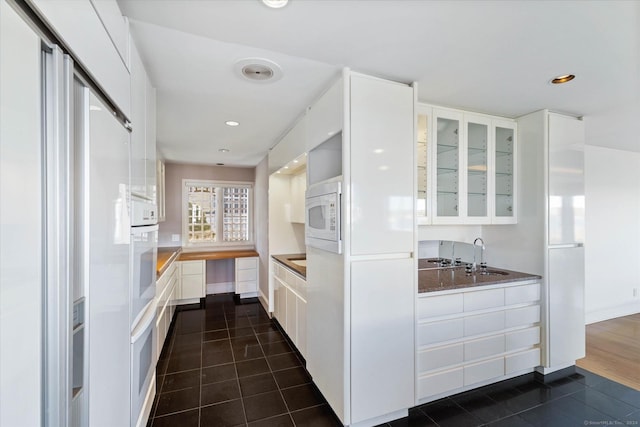 33 Palmer Rd, Waterford, CT 06385 - kitchen with white cabinets, dark tile patterned flooring, white appliances, glass insert cabinets, and recessed lighting