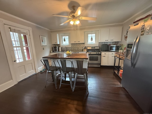352 Church St, Putnam, CT 06260 - kitchen featuring stainless steel appliances, white cabinets, dark wood-style floors, backsplash, and crown molding