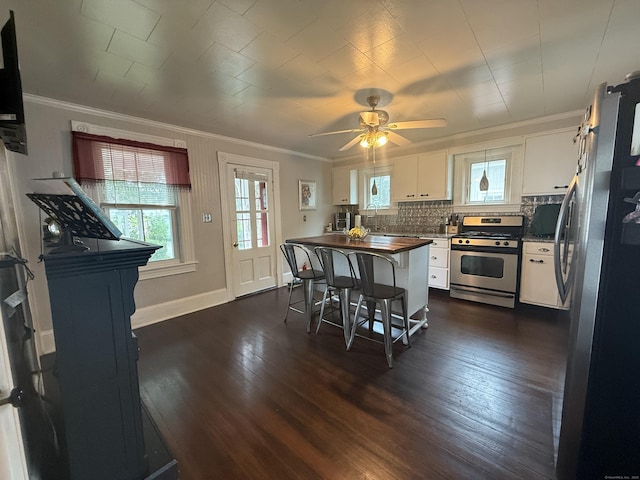 352 Church St, Putnam, CT 06260 - kitchen with appliances with stainless steel finishes, dark countertops, ornamental molding, white cabinetry, and dark wood-style flooring