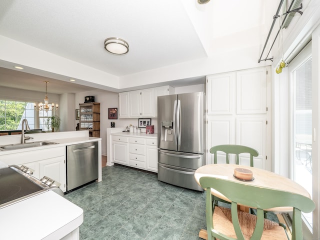 26 Wilton Crst Unit 26, Wilton, CT 06897 - kitchen featuring stainless steel appliances, white cabinetry, a chandelier, light countertops, and pendant lighting