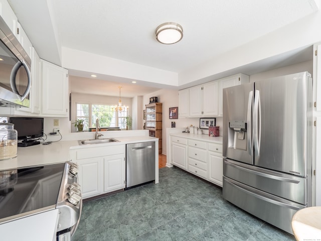 26 Wilton Crst Unit 26, Wilton, CT 06897 - kitchen with stainless steel appliances, a chandelier, white cabinets, light countertops, and a peninsula