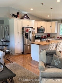 1 Brookfield Rd, Harwinton, CT 06791 - kitchen featuring appliances with stainless steel finishes, lofted ceiling, light wood-style flooring, a center island, and white cabinets