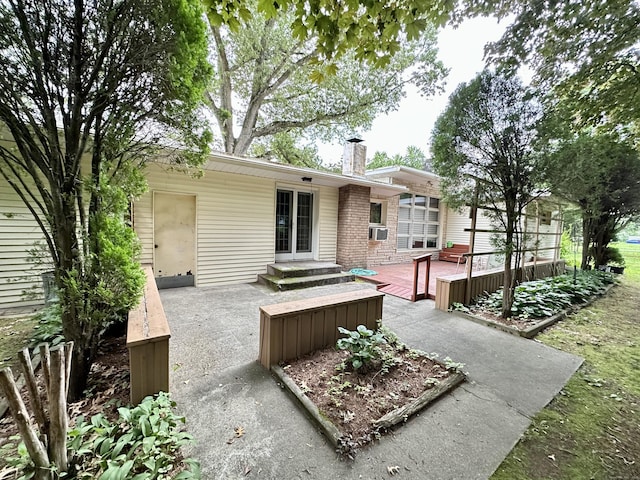 23 S Elm St, Windsor Locks, CT 06096 - back of property featuring a chimney, a deck, a patio, cooling unit, and french doors