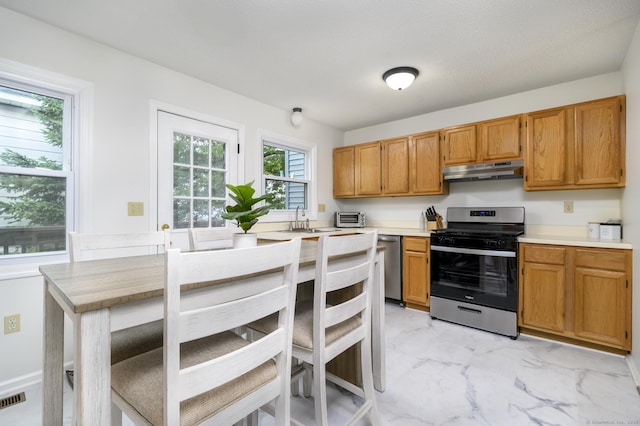 95 Elm St Apt 4, West Haven, CT 06516 - kitchen with stainless steel appliances, under cabinet range hood, light marble finish floors, light countertops, and brown cabinetry