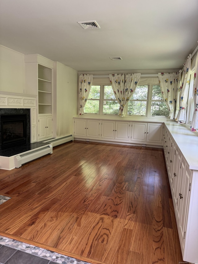 23 Mountain Rd, Mansfield, CT 06250 - unfurnished living room with healthy amount of natural light, baseboard heating, a fireplace, and dark wood-type flooring