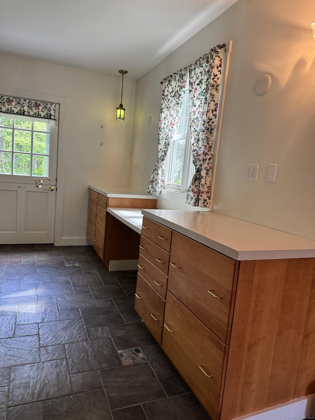 23 Mountain Rd, Mansfield, CT 06250 - kitchen with brown cabinetry, stone tile floors, light countertops, and hanging light fixtures