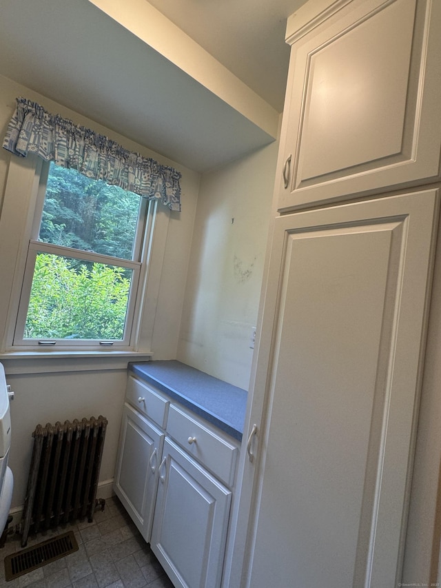 23 Mountain Rd, Mansfield, CT 06250 - kitchen featuring radiator heating unit, white cabinetry, and light countertops