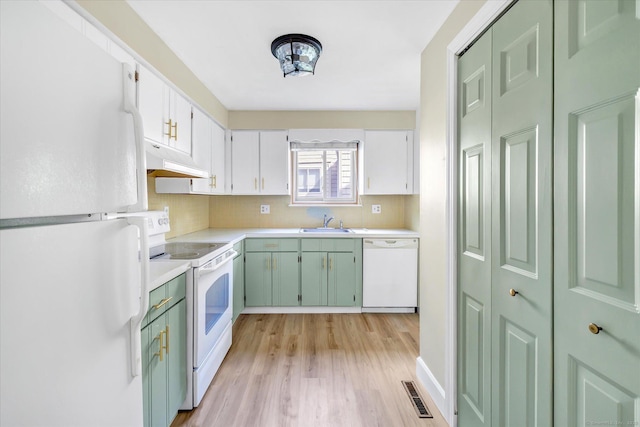 23 Happy Hollow Cir Unit B, Stratford, CT 06614 - kitchen with white appliances, under cabinet range hood, light countertops, light wood finished floors, and tasteful backsplash