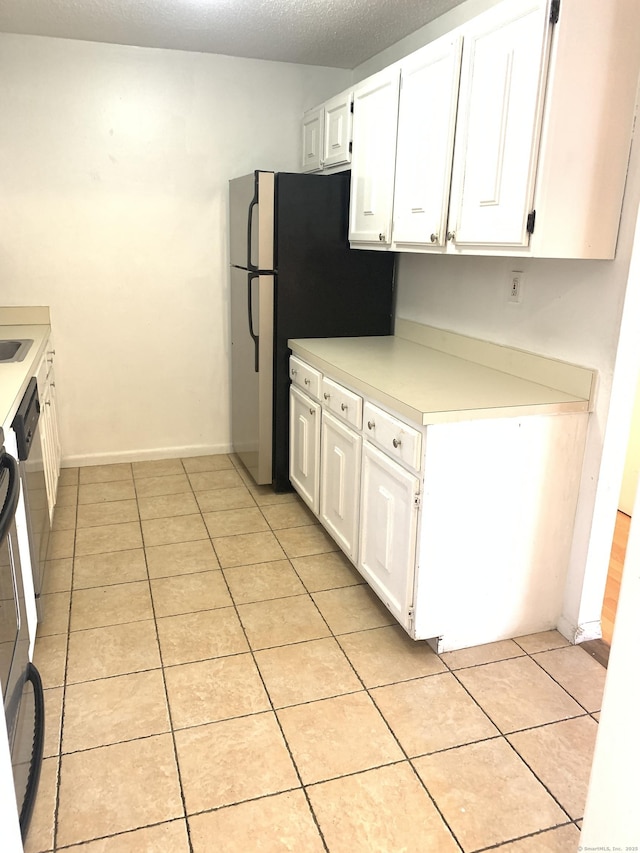 90 Kane St Apt C3, West Hartford, CT 06119 - kitchen featuring white cabinets, light tile patterned flooring, light countertops, freestanding refrigerator, and a textured ceiling