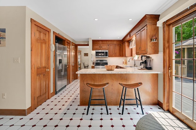 373 Broad Way, Coventry, CT 06238 - kitchen with stainless steel appliances, light flooring, a peninsula, light countertops, and tasteful backsplash