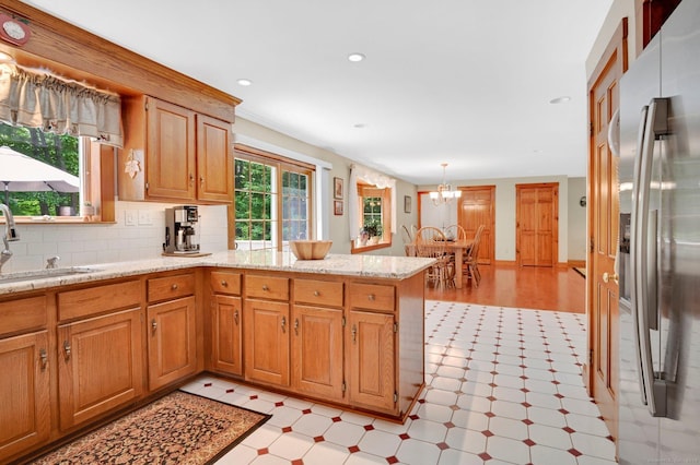 373 Broad Way, Coventry, CT 06238 - kitchen with stainless steel fridge with ice dispenser, light flooring, a peninsula, a chandelier, and light stone counters