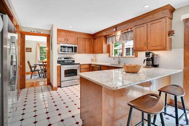 373 Broad Way, Coventry, CT 06238 - kitchen with appliances with stainless steel finishes, a peninsula, light floors, and backsplash