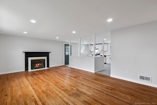 230 Green Rd, Manchester, CT 06042 - unfurnished living room with a fireplace with flush hearth, recessed lighting, and light wood-style flooring