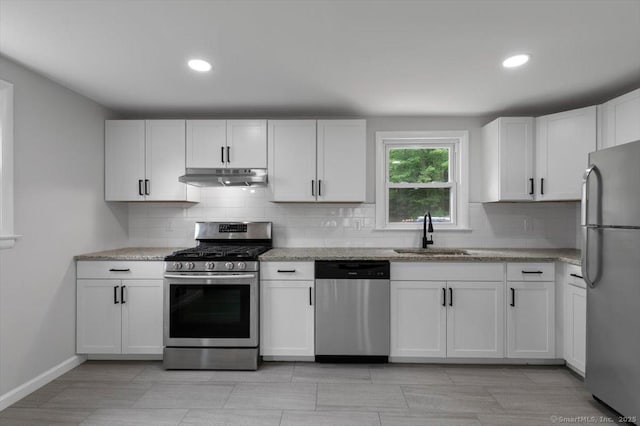 230 Green Rd, Manchester, CT 06042 - kitchen with appliances with stainless steel finishes, under cabinet range hood, decorative backsplash, recessed lighting, and light stone counters