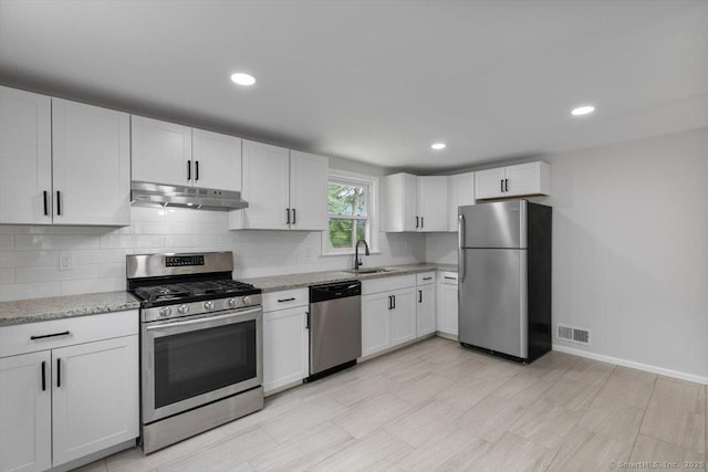 230 Green Rd, Manchester, CT 06042 - kitchen with stainless steel appliances, under cabinet range hood, backsplash, white cabinetry, and light stone counters