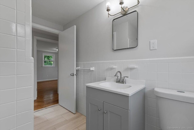230 Green Rd, Manchester, CT 06042 - half bath featuring vanity, tile walls, wainscoting, and wood finished floors