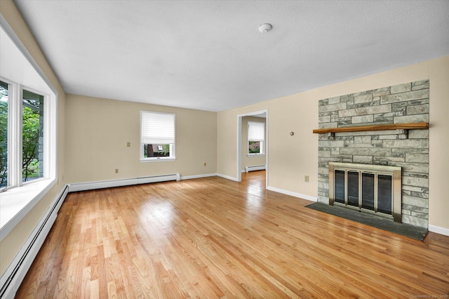 24 Iron Gate Ln, Cromwell, CT 06416 - unfurnished living room with a baseboard radiator, light wood-style flooring, and a fireplace