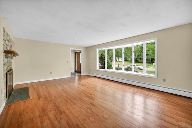 24 Iron Gate Ln, Cromwell, CT 06416 - unfurnished living room featuring light wood-style floors, a fireplace, and a baseboard radiator
