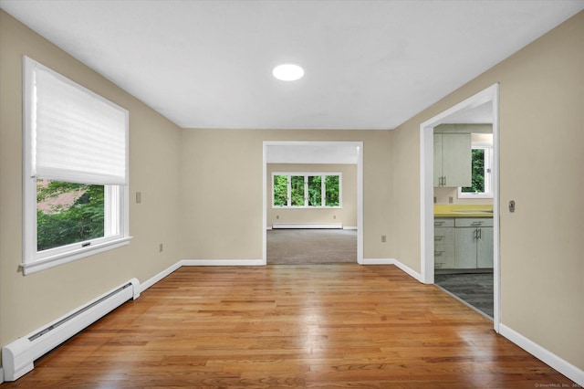 24 Iron Gate Ln, Cromwell, CT 06416 - empty room featuring a baseboard radiator, plenty of natural light, light wood-style flooring, and baseboard heating