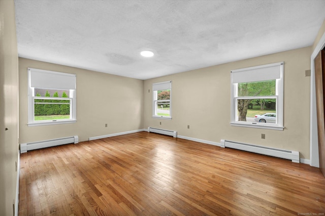 24 Iron Gate Ln, Cromwell, CT 06416 - spare room featuring a baseboard heating unit, light wood-type flooring, and a textured ceiling