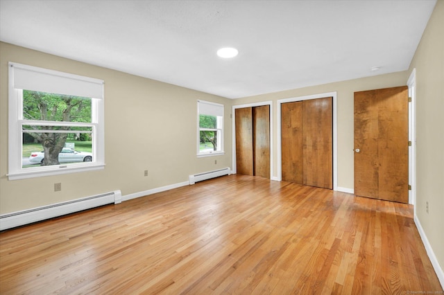 24 Iron Gate Ln, Cromwell, CT 06416 - unfurnished bedroom with two closets, baseboard heating, and light wood-style floors