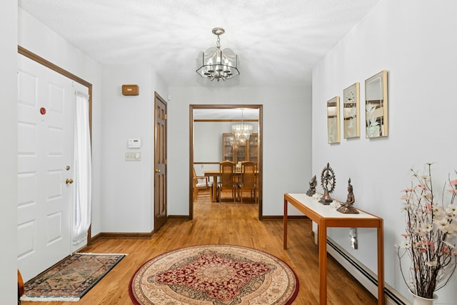 33 Shawnee Ln, Monroe, CT 06468 - entrance foyer featuring a chandelier, a baseboard heating unit, and light wood-type flooring