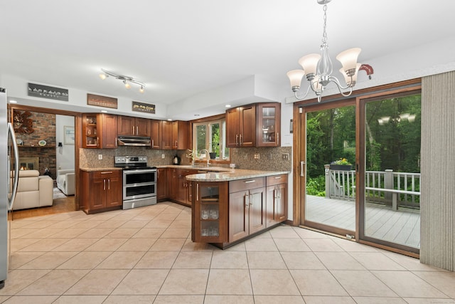 33 Shawnee Ln, Monroe, CT 06468 - kitchen with range with two ovens, under cabinet range hood, tasteful backsplash, light tile patterned floors, and a chandelier