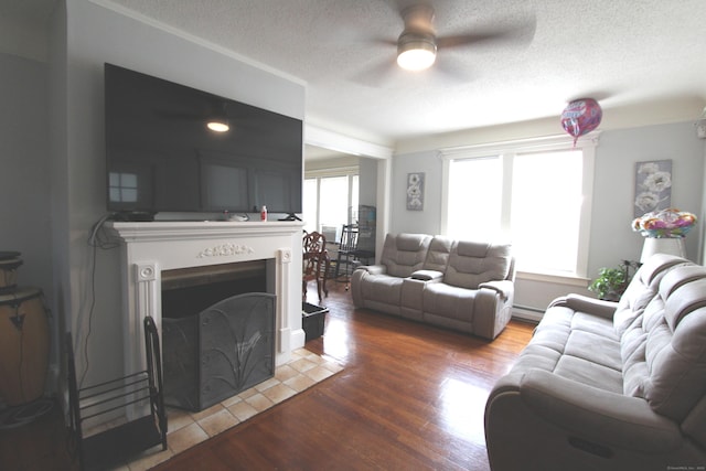 180 Victoria Rd, Hartford, CT 06114 - living area with a ceiling fan, a fireplace with flush hearth, light wood-type flooring, a textured ceiling, and a baseboard radiator