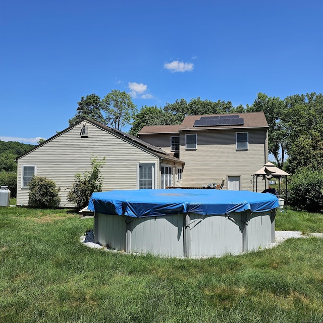 50 Meadow St, Meriden, CT 06451 - rear view of house with solar panels, a lawn, and a covered pool