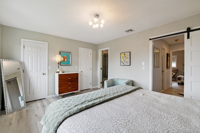 28 Biltmore Park Unit 28, Bloomfield, CT 06002 - bedroom featuring a barn door and light wood-style floors