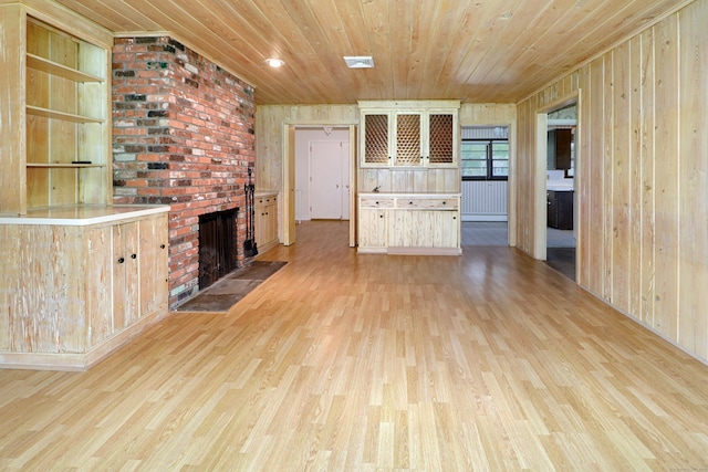 355 Surrey Ln, Fairfield, CT 06824 - unfurnished living room featuring wooden ceiling, light wood-style floors, a fireplace, and wood walls
