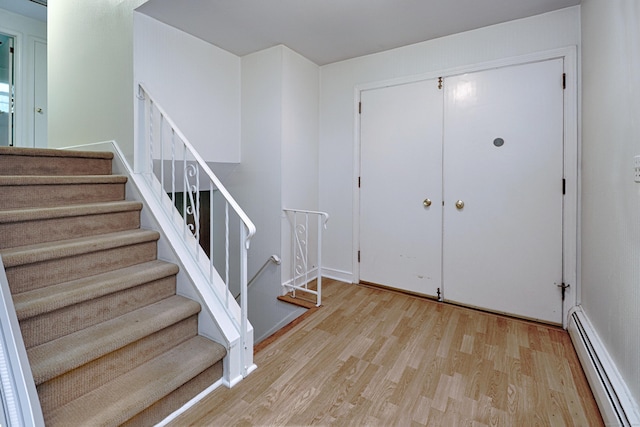 355 Surrey Ln, Fairfield, CT 06824 - foyer with a baseboard heating unit, wood finished floors, and stairway