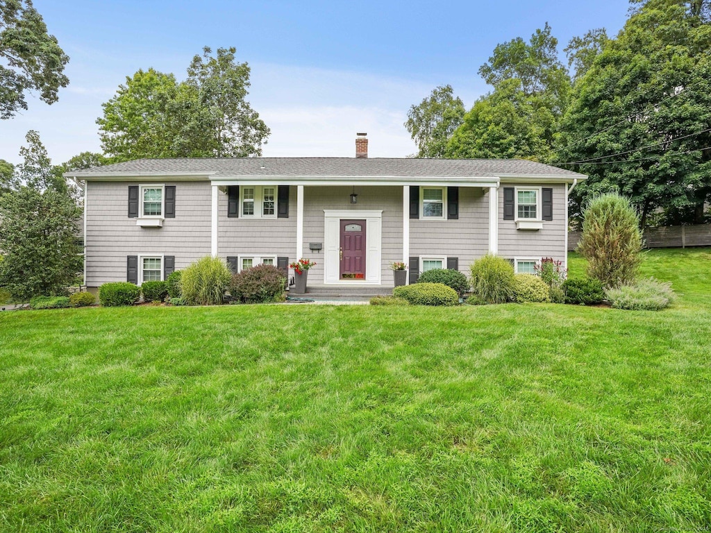 24 Silwen Ln, Norwalk, CT 06851 - bi-level home with a chimney, a front yard, and a shingled roof