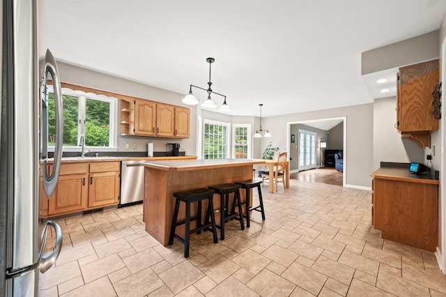 70 Shane Dr, Southbury, CT 06488 - kitchen with appliances with stainless steel finishes, a center island, a breakfast bar, open shelves, and hanging light fixtures