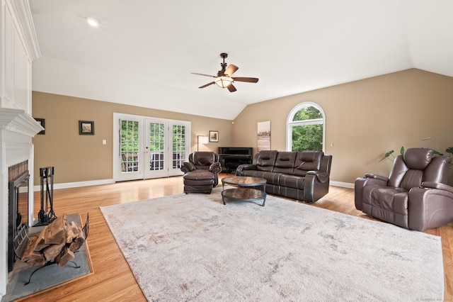 70 Shane Dr, Southbury, CT 06488 - living room with a fireplace with raised hearth, vaulted ceiling, a ceiling fan, light wood-type flooring, and french doors