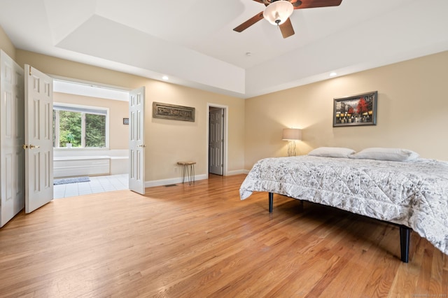 70 Shane Dr, Southbury, CT 06488 - bedroom with light wood-type flooring, a raised ceiling, and a ceiling fan