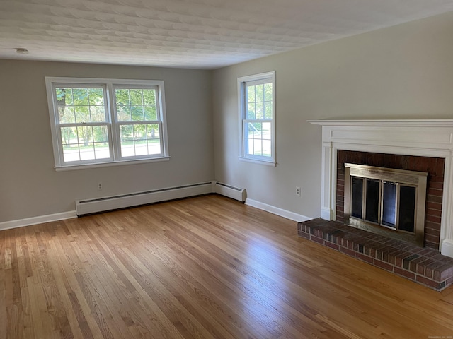 18 Depietro Dr, East Hartford, CT 06118 - unfurnished living room with a baseboard heating unit, wood finished floors, and a brick fireplace