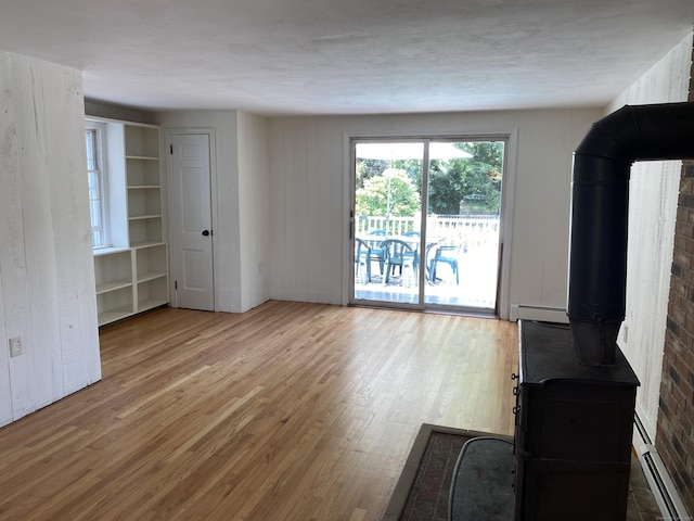 18 Depietro Dr, East Hartford, CT 06118 - unfurnished living room featuring a wood stove, wood finished floors, and baseboard heating