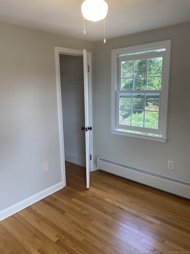 18 Depietro Dr, East Hartford, CT 06118 - unfurnished bedroom with a baseboard heating unit, light wood finished floors, and a spacious closet