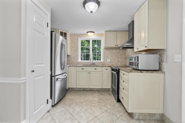 286 Marlborough St, Portland, CT 06480 - kitchen with stainless steel appliances, wall chimney range hood, cream cabinetry, backsplash, and light stone counters