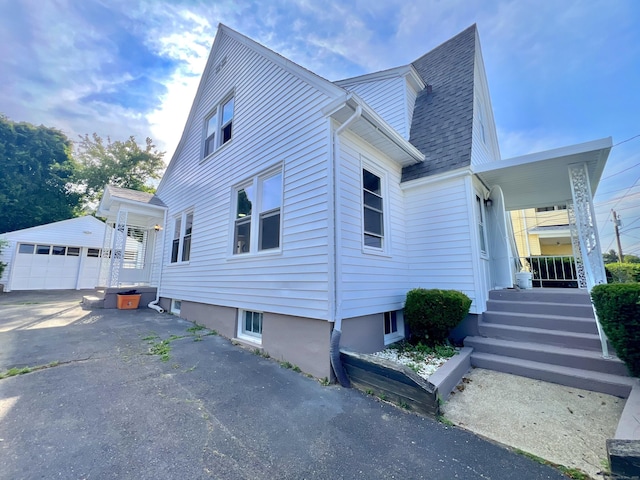 50 Norman St, Waterbury, CT 06708 - view of property exterior with an outbuilding, a detached garage, a shingled roof, and a porch