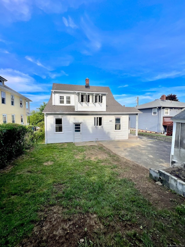 50 Norman St, Waterbury, CT 06708 - rear view of house featuring a patio area, a lawn, a chimney, and a shingled roof