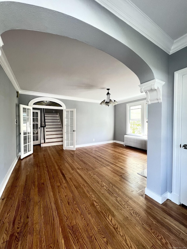 50 Norman St, Waterbury, CT 06708 - unfurnished living room with radiator, arched walkways, ornamental molding, wood finished floors, and a chandelier