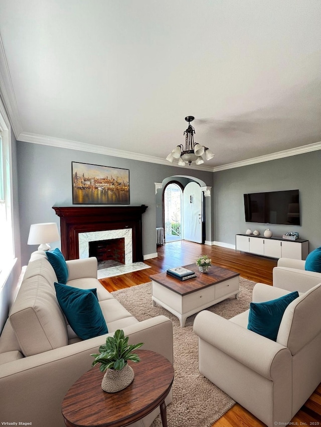 50 Norman St, Waterbury, CT 06708 - living area featuring a chandelier, wood finished floors, ornamental molding, a premium fireplace, and arched walkways