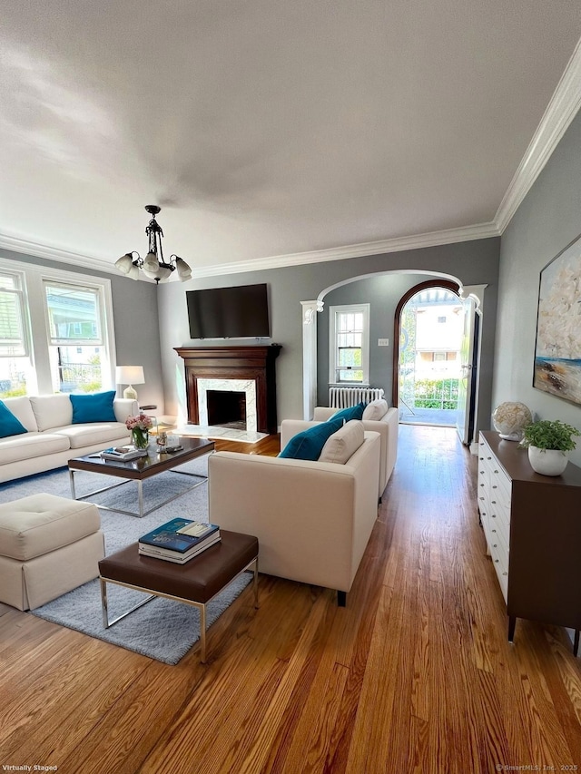 50 Norman St, Waterbury, CT 06708 - living area with ornamental molding, healthy amount of natural light, arched walkways, wood finished floors, and a chandelier