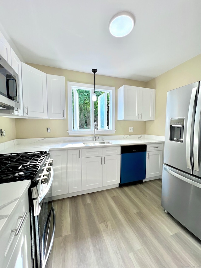 50 Norman St, Waterbury, CT 06708 - kitchen featuring appliances with stainless steel finishes, light wood-type flooring, and white cabinets