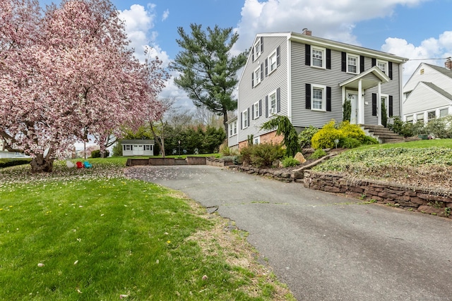 52 Lincoln St, Cromwell, CT 06416 - view of side of home featuring a chimney, a lawn, and driveway