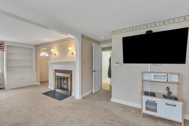 52 Lincoln St, Cromwell, CT 06416 - unfurnished living room featuring wallpapered walls, a brick fireplace, light carpet, and arched walkways