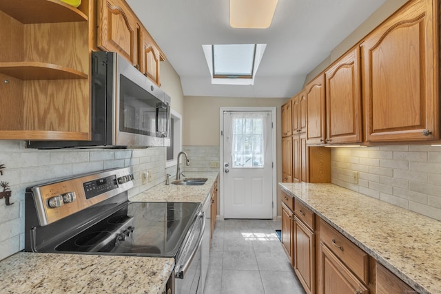 52 Lincoln St, Cromwell, CT 06416 - kitchen featuring stainless steel appliances, a skylight, open shelves, decorative backsplash, and light stone counters